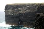 The central sandy portion of the cliff represents the cross-bedded Tullig Formation sands, and silts. The channeling and sorting of the quartz rich character of the sands on delta front reflect waves impinging on the delta front sands that filled distributary channels and/or proximal bar sands (Andy Pulham personal communication and Martinsen et al., 2008). The upper portion of cliff is composed of sand stringers and shales of a marine bay within wave base. The lower portion of the cliff represents silts, shales and some thin sands the accumulated in water that deepens down section to below wave base. A delta mouth gulley lies just below the central sandstone unit. This cliff represents approximately 50m of section. These sediments are Upper Carboniferous or Namurian in age.